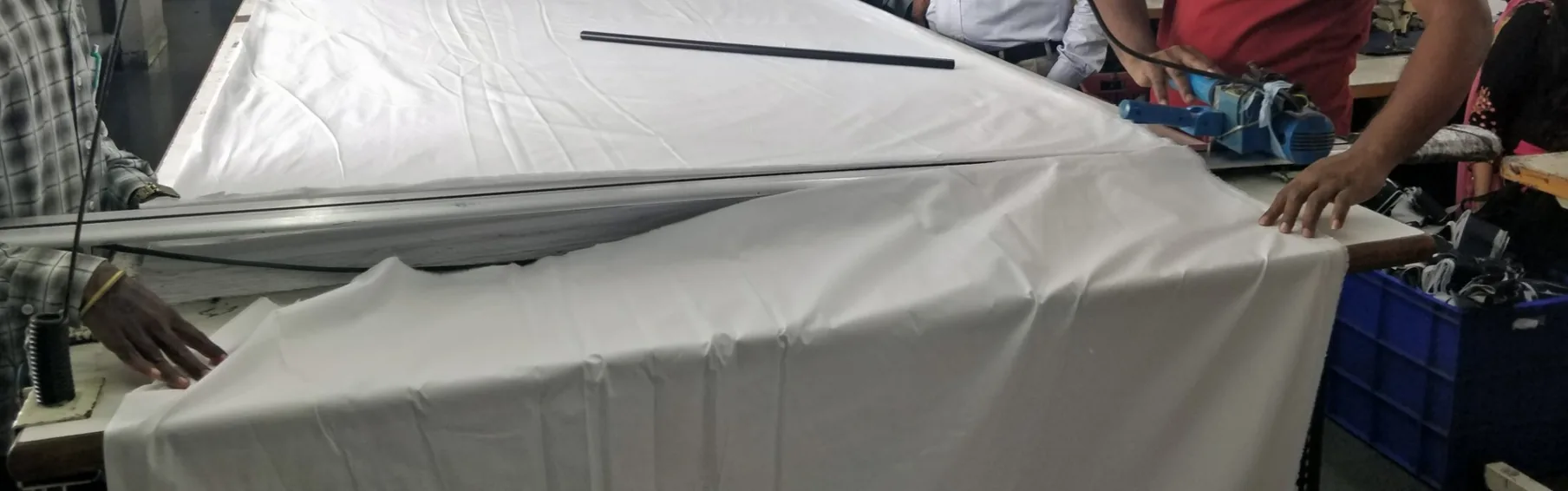 Cutting layered white linen fabric