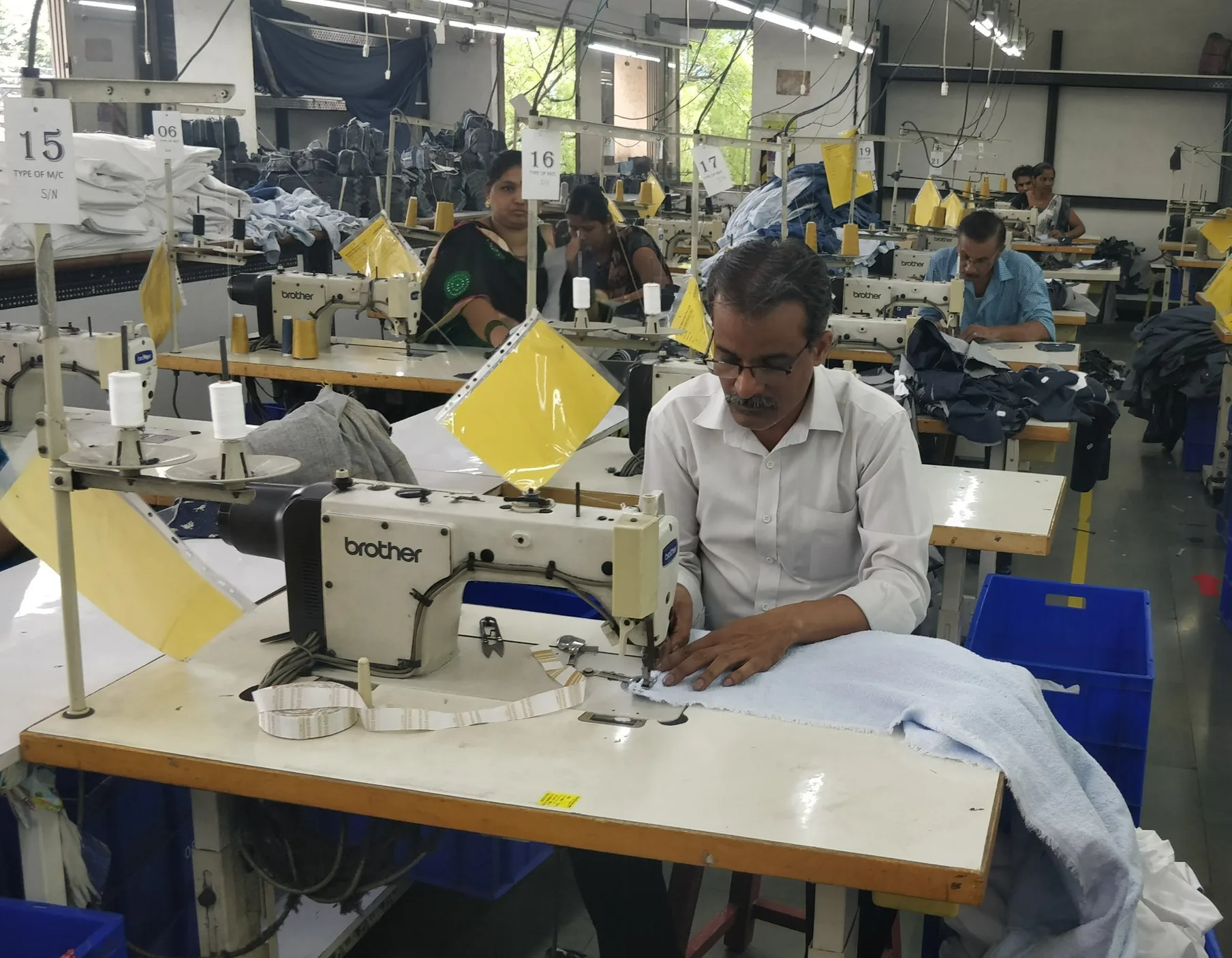 Hands guiding a hem under the sewing needle